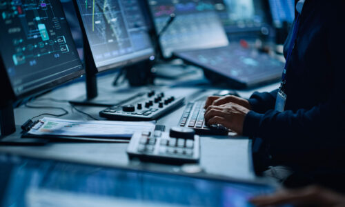 Close Up of a Professional Office Specialist Working on Desktop Computer in Modern Technological Monitoring Control Room with Digital Screens. Manager Typing on keyboard and Using Mouse.