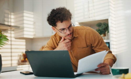 Man, documents and laptop for budget in home, review and stress for finance, investment and wealth planning. Person, computer and paperwork with taxes, bills and thinking with report at apartment.